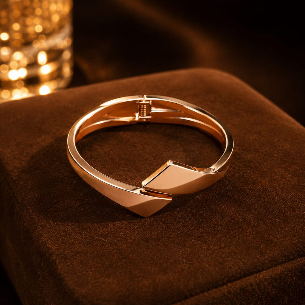 Rose gold bracelet on a brown textured surface with blurred lights in the background