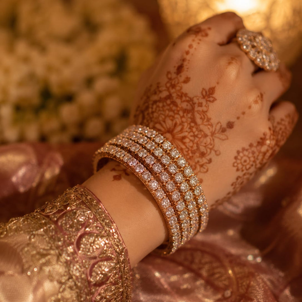 Close-up of a hand with intricate henna design and multiple bracelets, held near a lit candle.