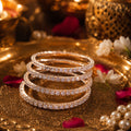 Stack of diamond-studded bangles on a gold tray with decorative elements