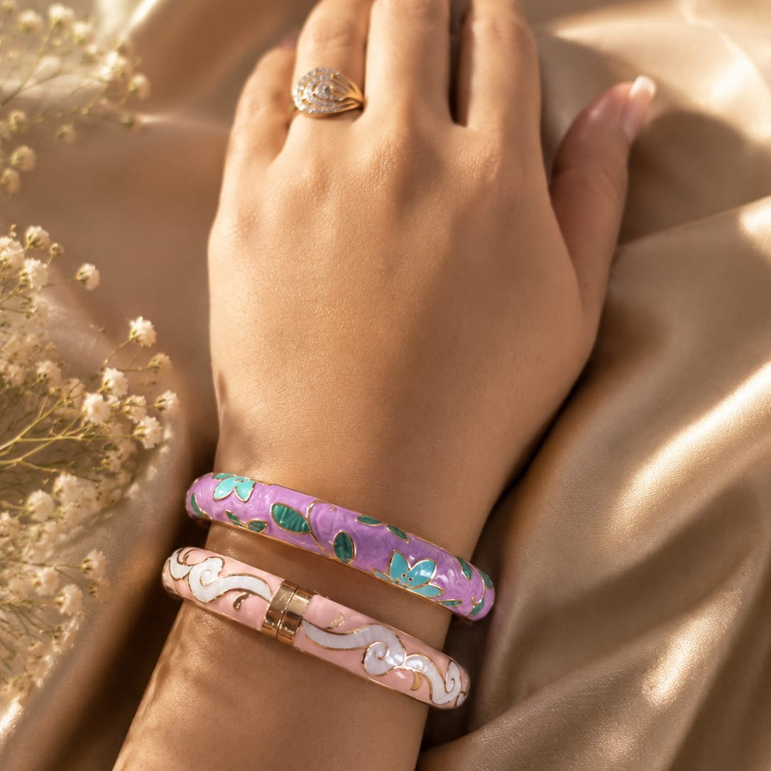 Hand wearing a ring and two bracelets on a beige fabric background