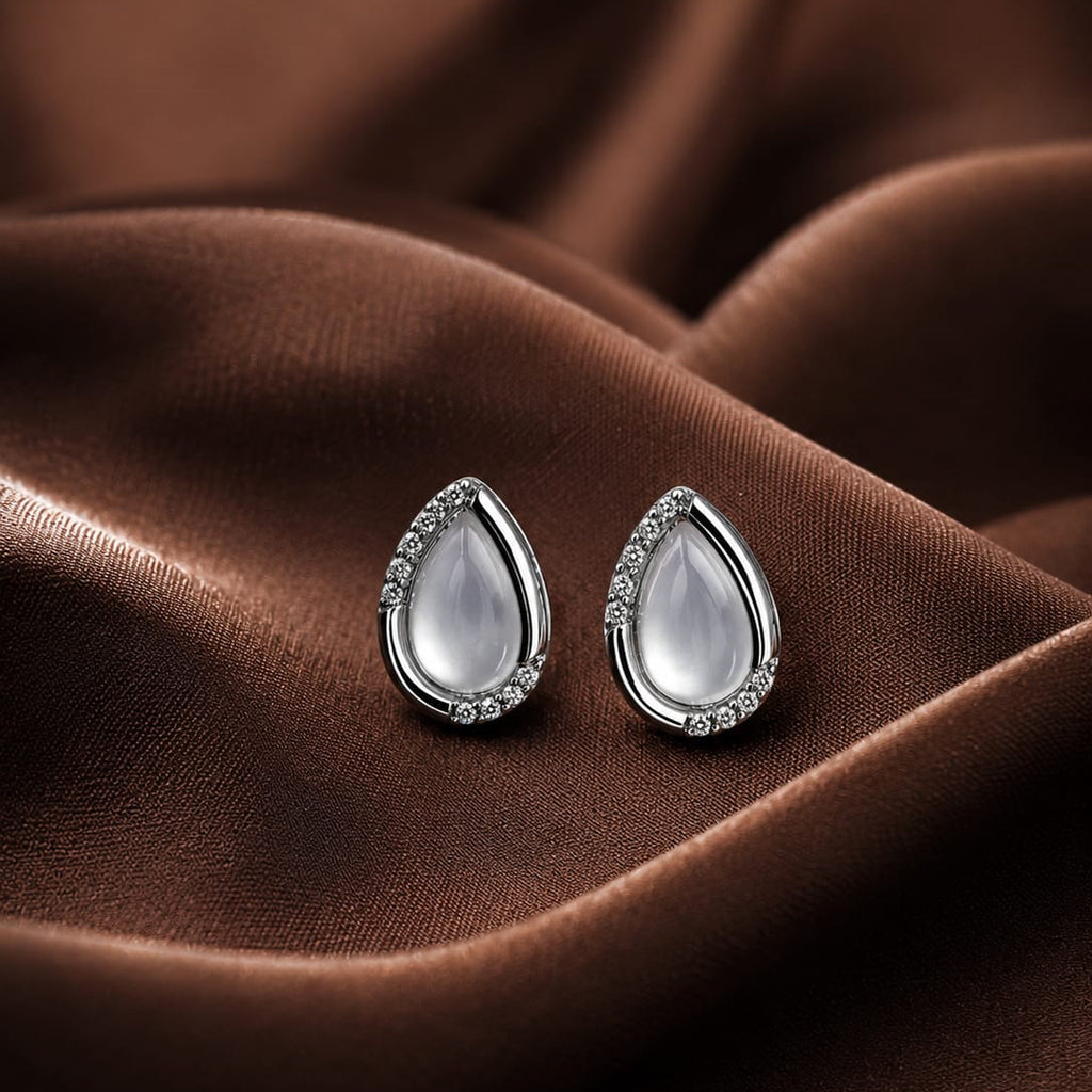 Teardrop-shaped earrings on a brown fabric background