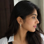 Woman wearing a pearl earring with a neutral background