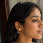 Woman wearing earrings with a neutral background