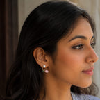 Woman wearing earrings with a neutral background
