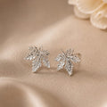 Silver leaf earrings on a beige fabric background