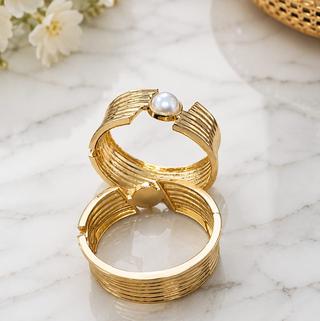 Gold bangle
 with a pearl on a marble surface