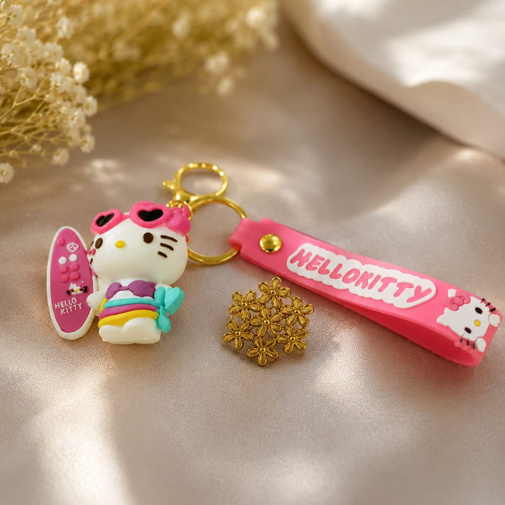Hello Kitty keychain with pink bow and rainbow dress on a beige surface.