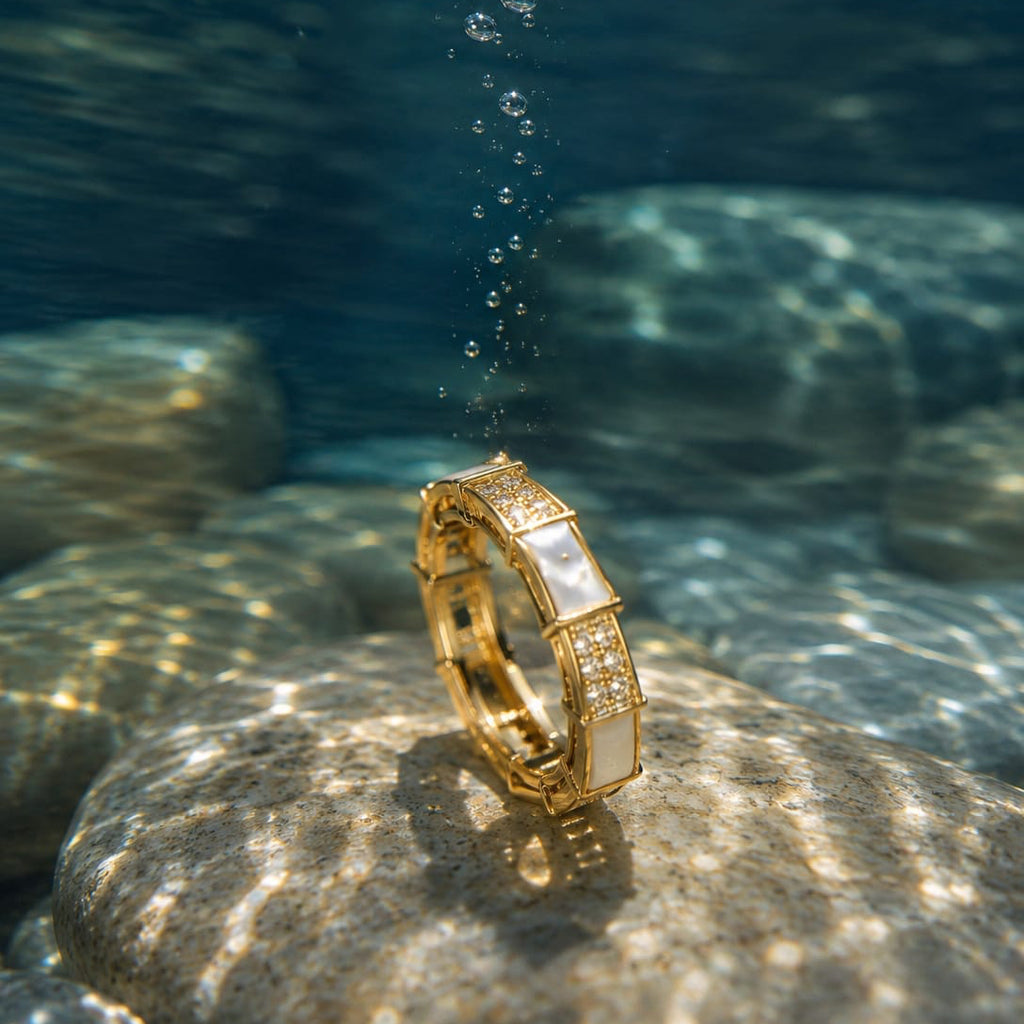 Gold bracelet on a rock underwater with sunlight filtering through