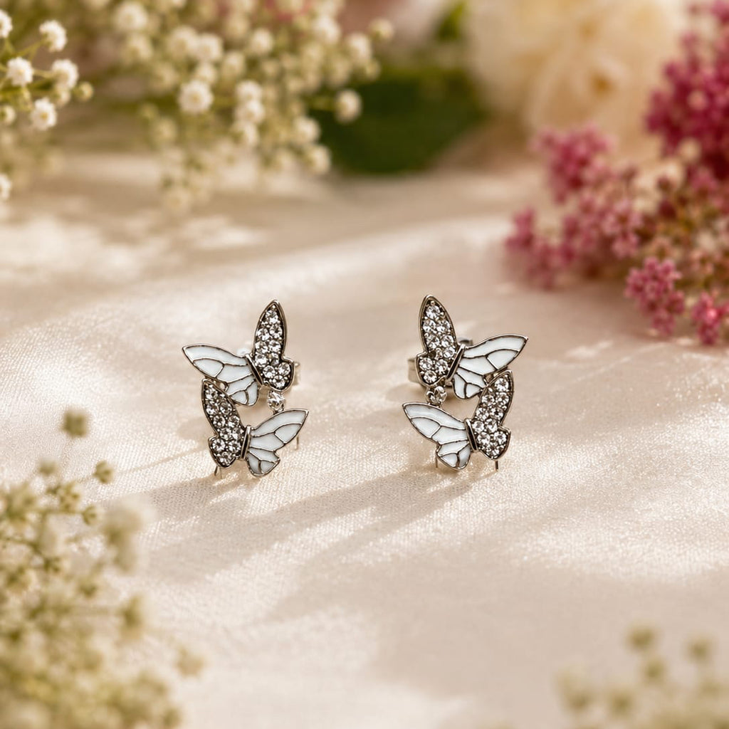 Butterfly earrings on a soft fabric background with flowers