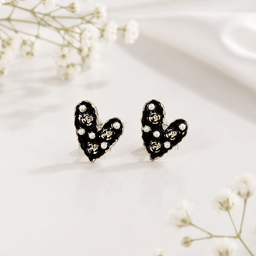 Heart-shaped earrings with black and white design on a light background
