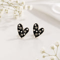 Heart-shaped earrings with black and white design on a light background
