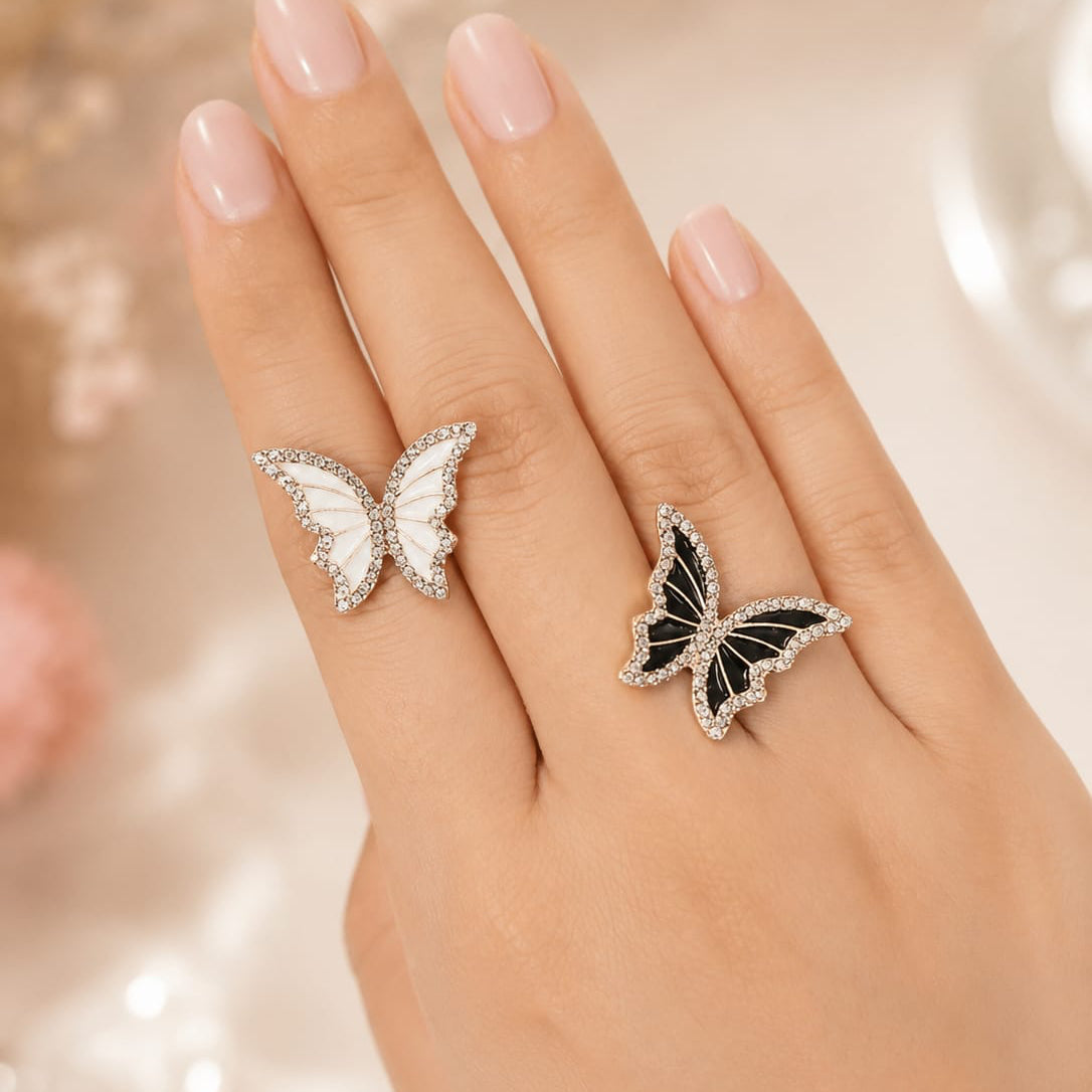 Butterfly-shaped rings on a hand with a soft, blurred background