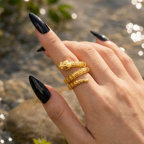 Hand with gold rings on a blurred natural background