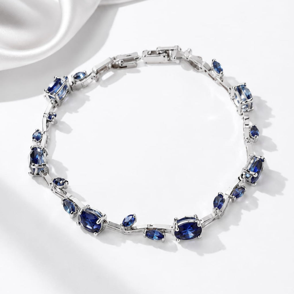 Jewelry bracelet with blue gemstones on a white satin background