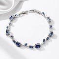 Jewelry bracelet with blue gemstones on a white satin background