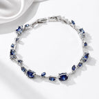 Jewelry bracelet with blue gemstones on a white satin background