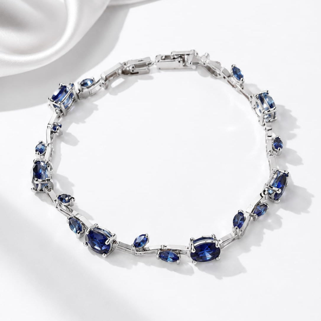 Jewelry bracelet with blue gemstones on a white satin background