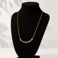 Necklace with multicolored beads on a black mannequin bust against a white background