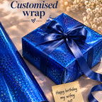 Blue gift box with a bow, blue wrapping paper, and a card saying 'Happy birthday my wifey' on a light background.