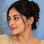 Woman wearing a beige embroidered outfit with a blue background
