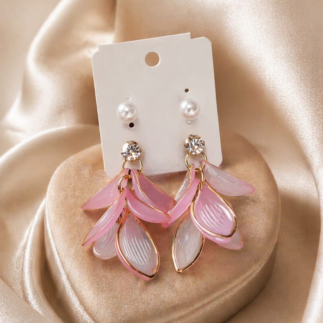 Pink floral earrings on a heart-shaped stand with a beige satin background